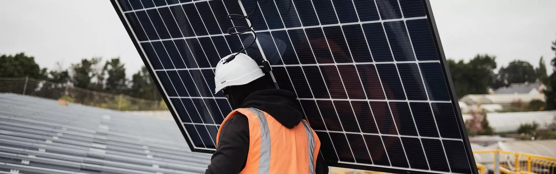 Salarié Triangle Energie en train d'installer un panneau photovoltaïque sur un hangar solaire