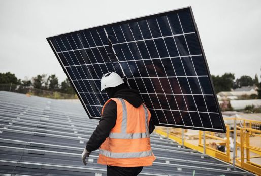 Salarié Triangle Energie en train d'installer un panneau photovoltaïque sur un hangar solaire