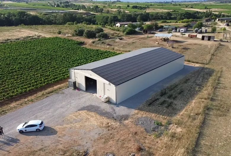 Bâtiment photovoltaïque symétrique avec une exposition Est-Ouest dans l'Hérault, réalisé par Triangle Énergie pour un viticulteur