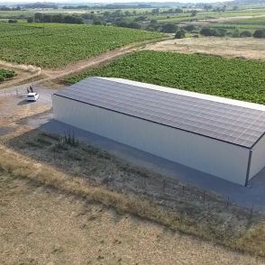 Bâtiment photovoltaïque symétrique avec une exposition Est-Ouest dans l'Hérault, réalisé par Triangle Énergie pour un viticulteur