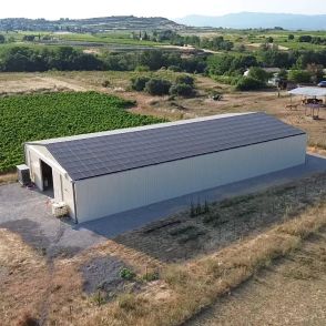 Bâtiment photovoltaïque symétrique avec une exposition Est-Ouest dans l'Hérault, réalisé par Triangle Énergie pour un viticulteur