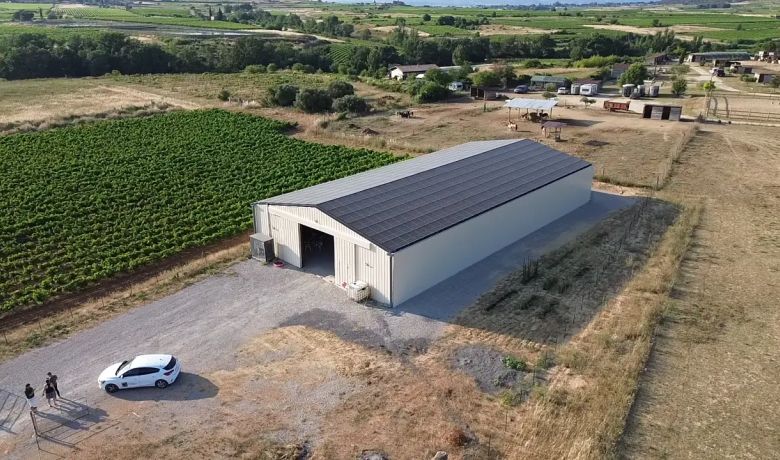 Bâtiment photovoltaïque symétrique avec une exposition Est-Ouest dans l'Hérault, réalisé par Triangle Énergie pour un viticulteur