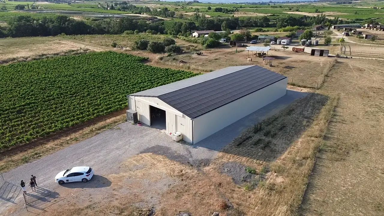 Bâtiment photovoltaïque symétrique avec une exposition Est-Ouest dans l'Hérault, réalisé par Triangle Énergie pour un viticulteur