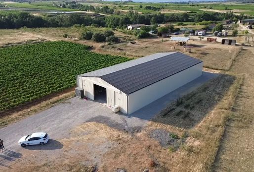 Bâtiment photovoltaïque symétrique avec une exposition Est-Ouest dans l'Hérault, réalisé par Triangle Énergie pour un viticulteur